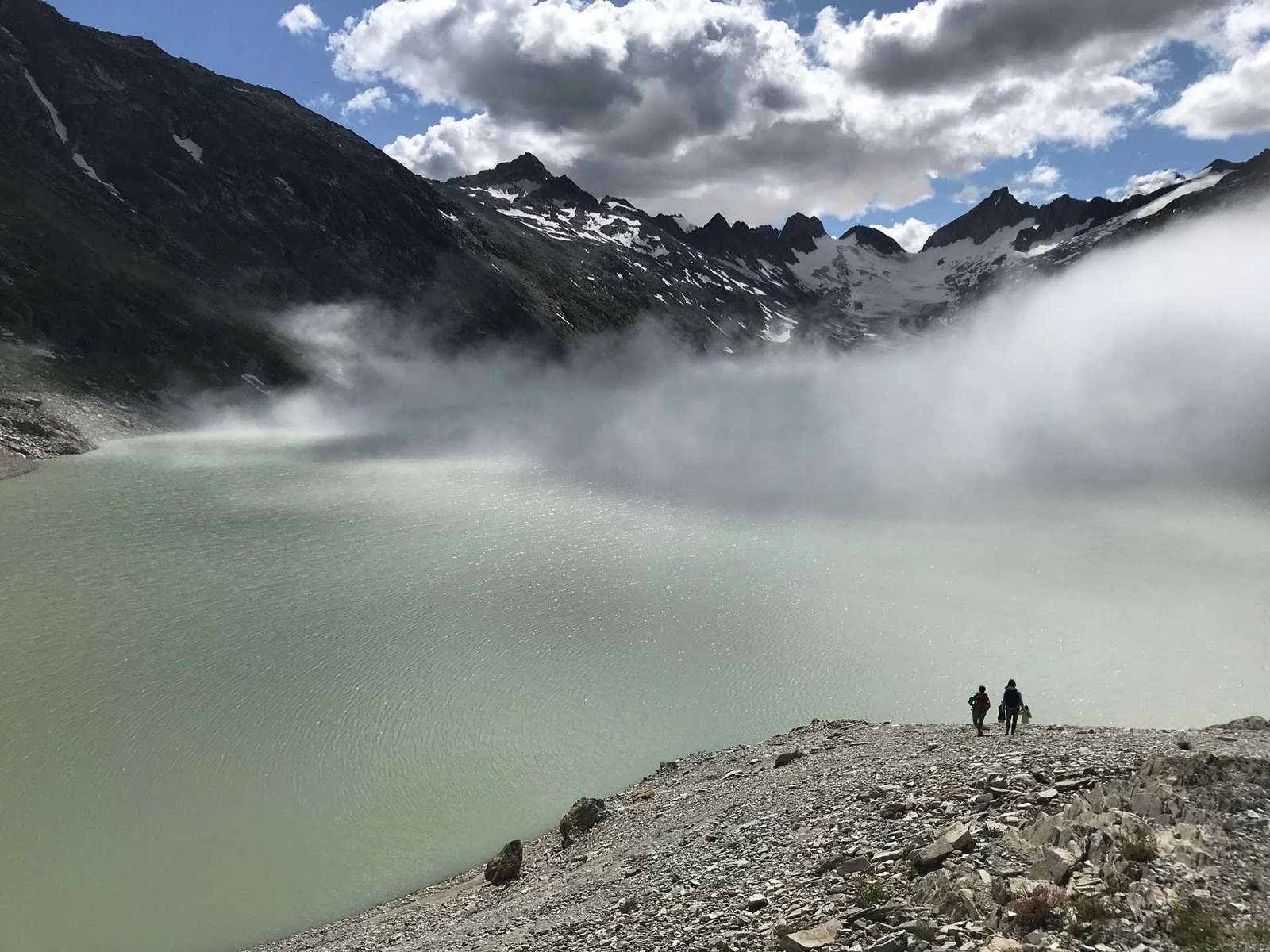 Snow-capped mountains rising above mist and still water